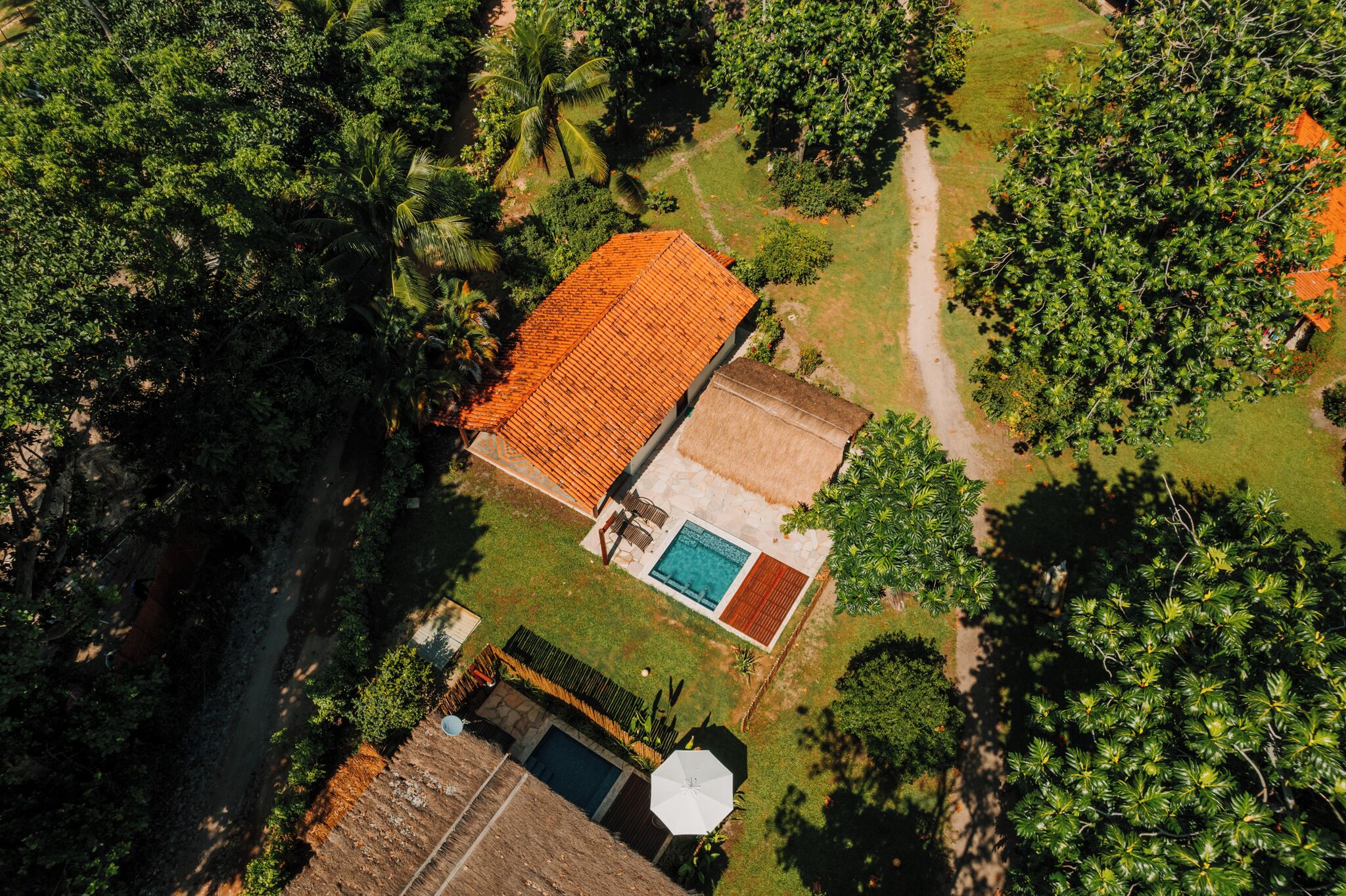 Vista aérea de una propiedad con piscina, zona de patio y jardín.