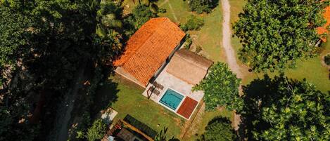 Vista aérea de una propiedad con piscina, zona de patio y jardín.