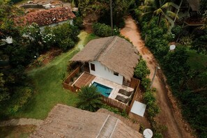 Escape to a serene tropical retreat surrounded by lush greenery and a pool.