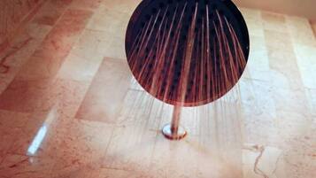 A round, dark-colored object with a central pole, possibly a decorative item, on a tiled floor.