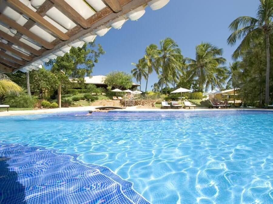 Een buitenzwembad, parasols bij het zwembad en ligstoelen