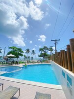 Una piscina al aire libre, tumbonas