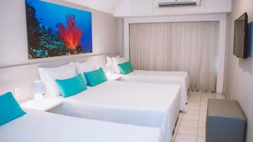 A hotel room with two beds, a painting of a coral reef, an air conditioning unit, and a television on the wall.