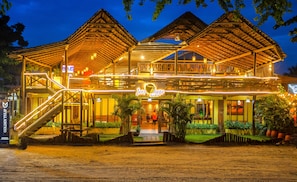 Ein Hotel mit Holzbauweise, mehreren Etagen und einem Schild mit der Aufschrift 'Jeri Village Hotel'.