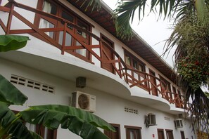A building with a white facade, wooden balconies, and air conditioning units. - Jeri Village Hotel (Jijoca de Jericoacoara)