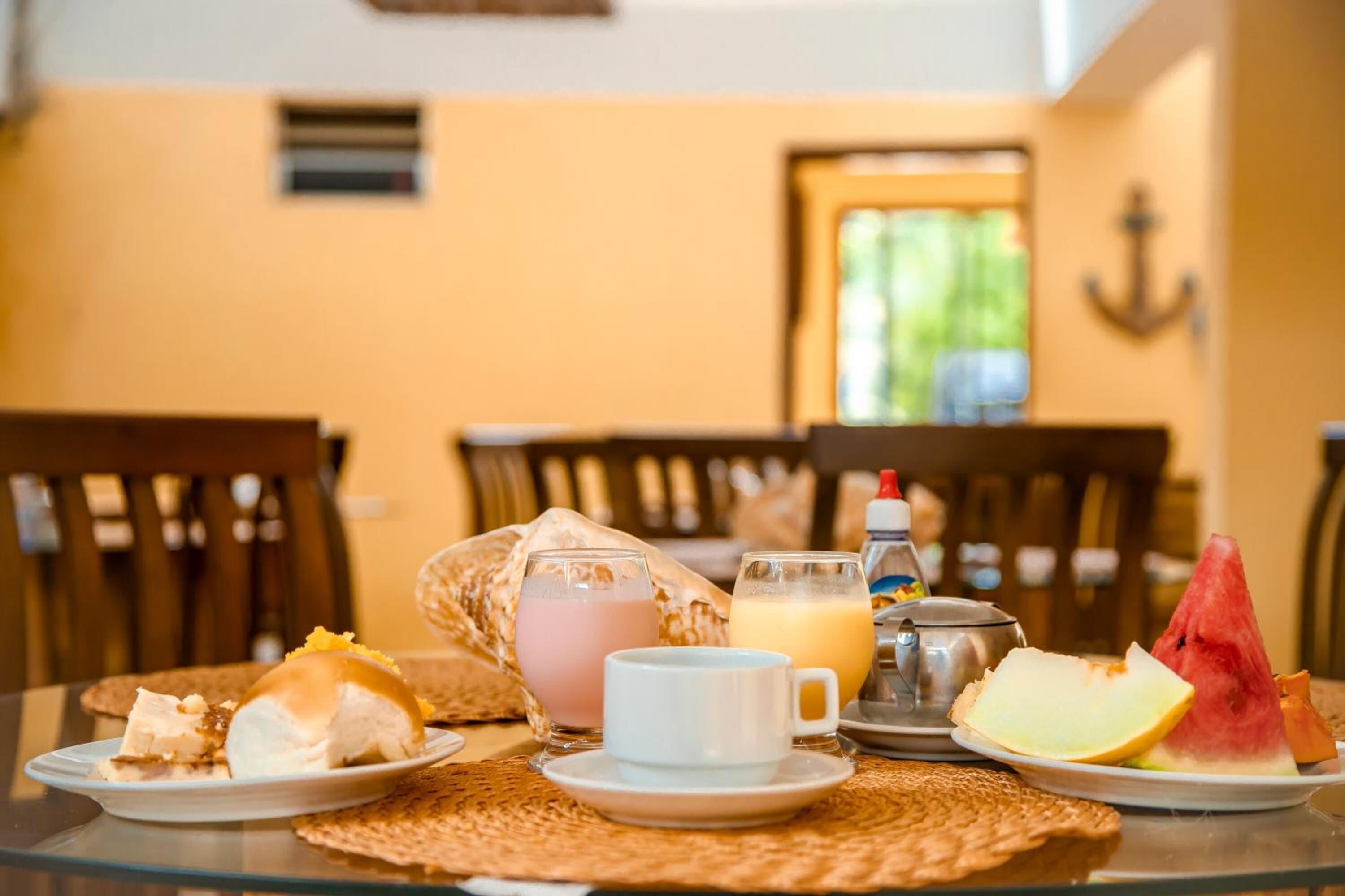 A breakfast setting with a plate of toast, a cup of coffee, and a glass of orange juice on a glass table.