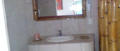 A bathroom with a sink, mirror, and shower curtain.