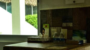 A wooden counter with a tissue box, a bottle, and a framed picture.