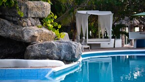 A pool with a rock formation and a white gazebo. - Bon Jesús Hotel (Tecolutla)