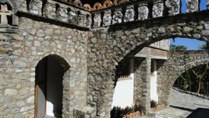 A stone archway leading to a building with a white facade and a tiled roof. - Hotel Paraiso Escondido (Puerto Escondido)