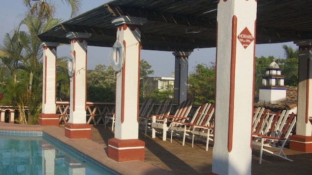 A pool area with lounge chairs and a covered seating area. - Hotel Paraiso Escondido (Puerto Escondido)