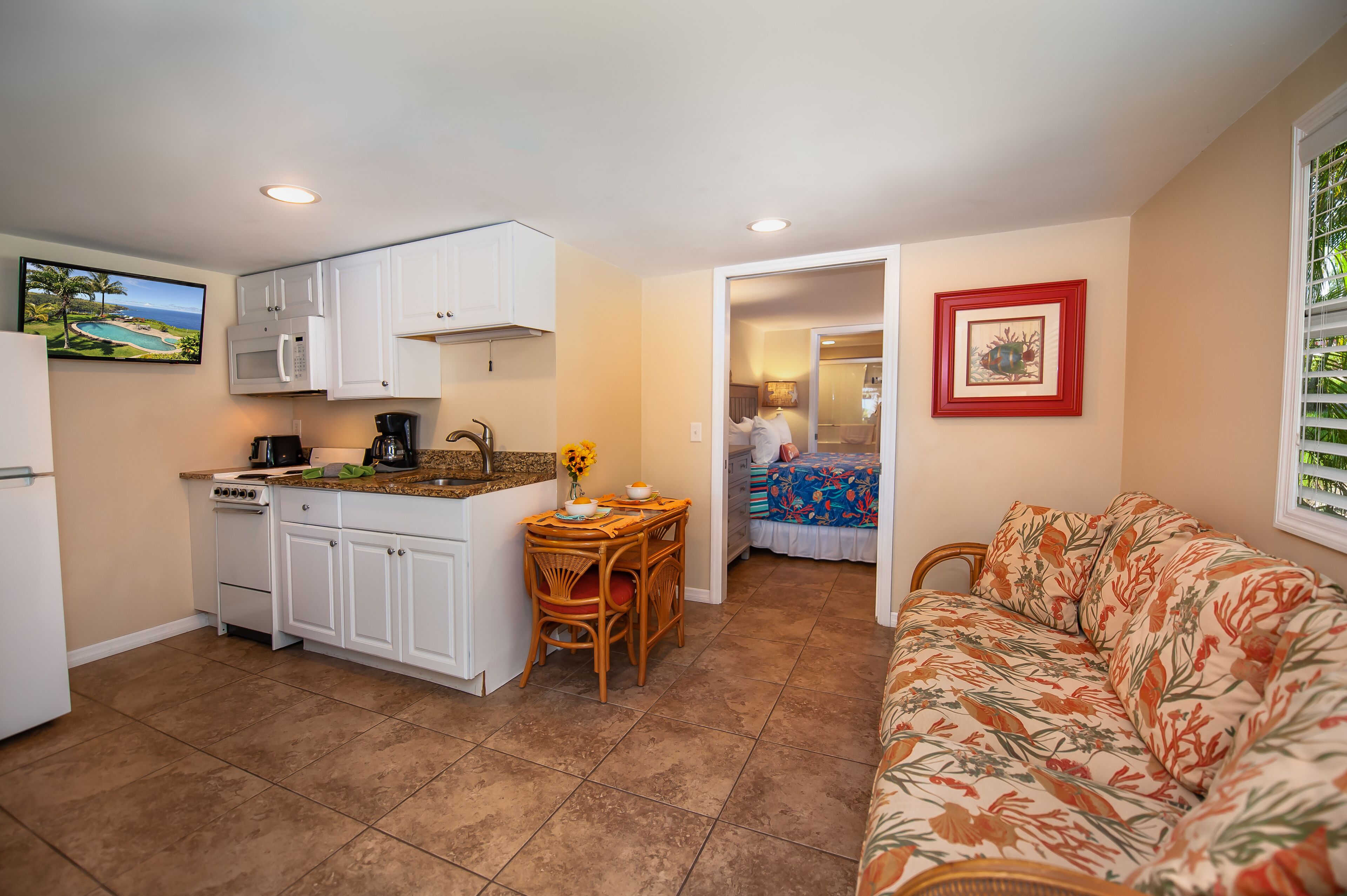 A compact living space with a kitchenette, a dining area, and a sofa.