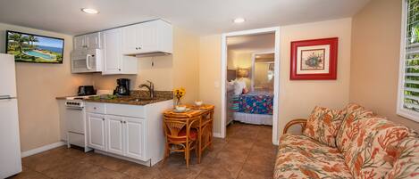A compact living space with a kitchenette, a dining area, and a sofa.