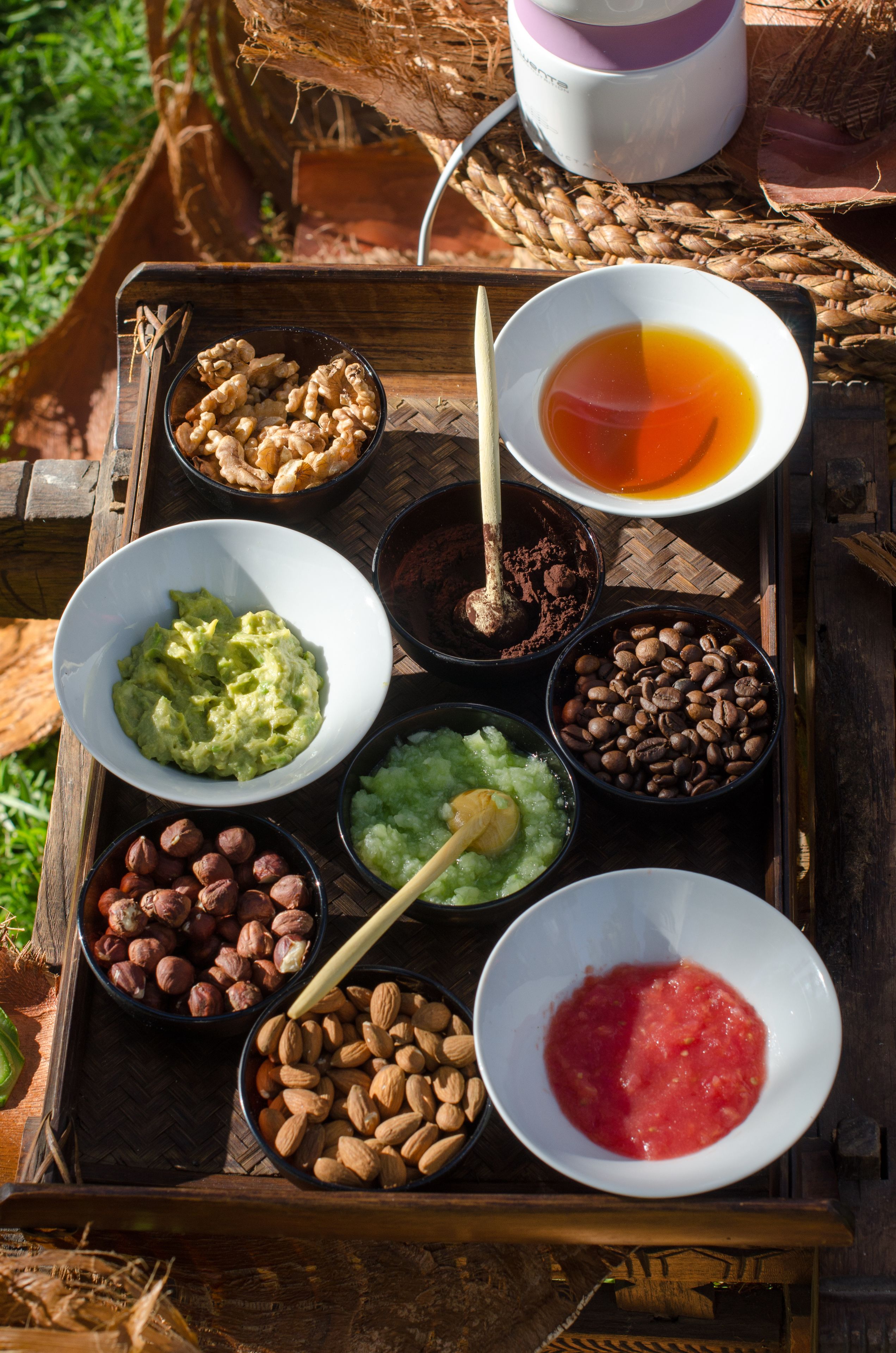 A tray with various food items including nuts, chocolate, and a bowl of red sauce.