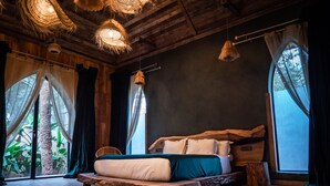 A rustic bedroom with a wooden bed, woven ceiling lights, and large windows with sheer curtains. - Lodge K Hôtel & Spa (Marrakech)