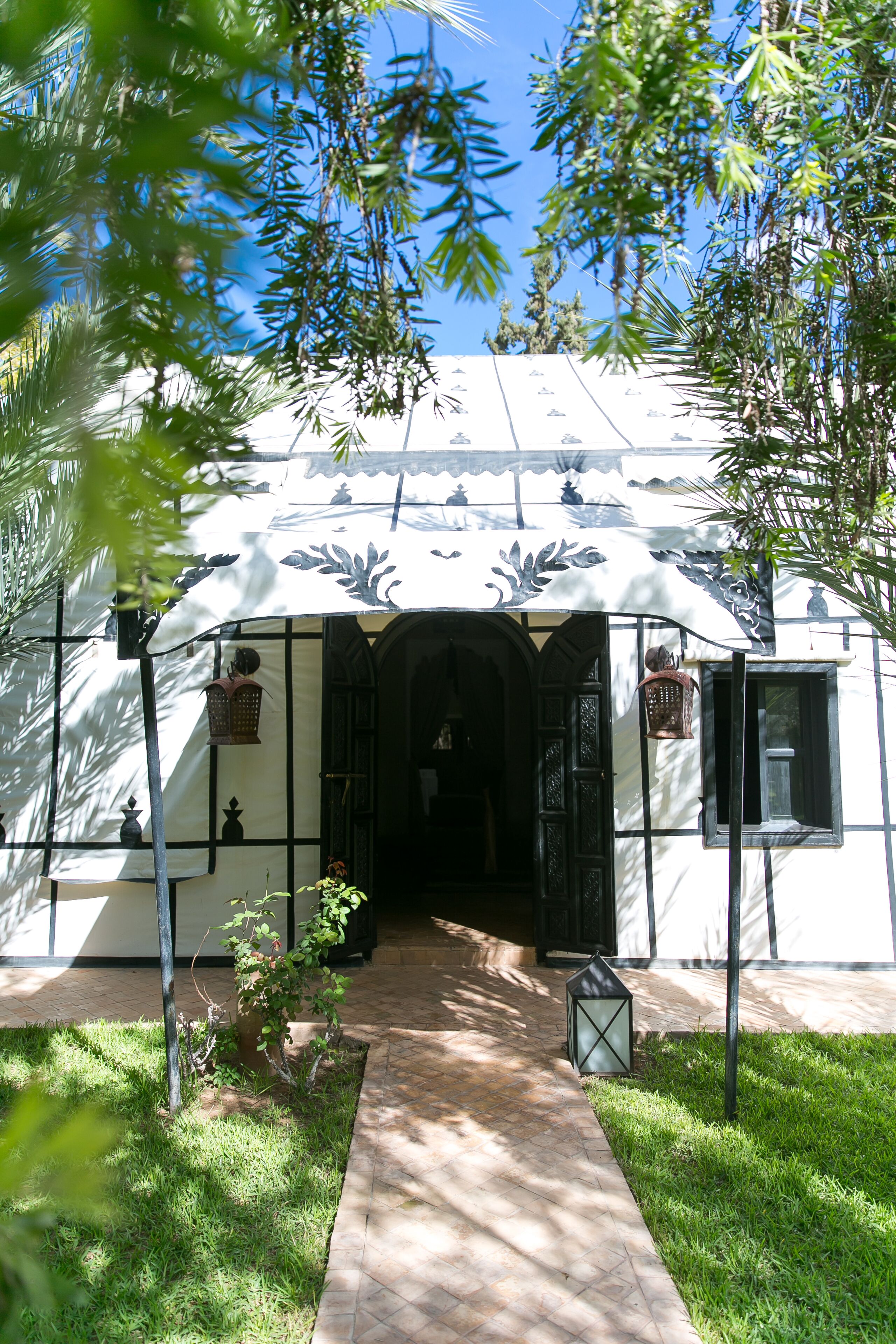 A building with a white facade, black-framed windows, and a tiled entrance.