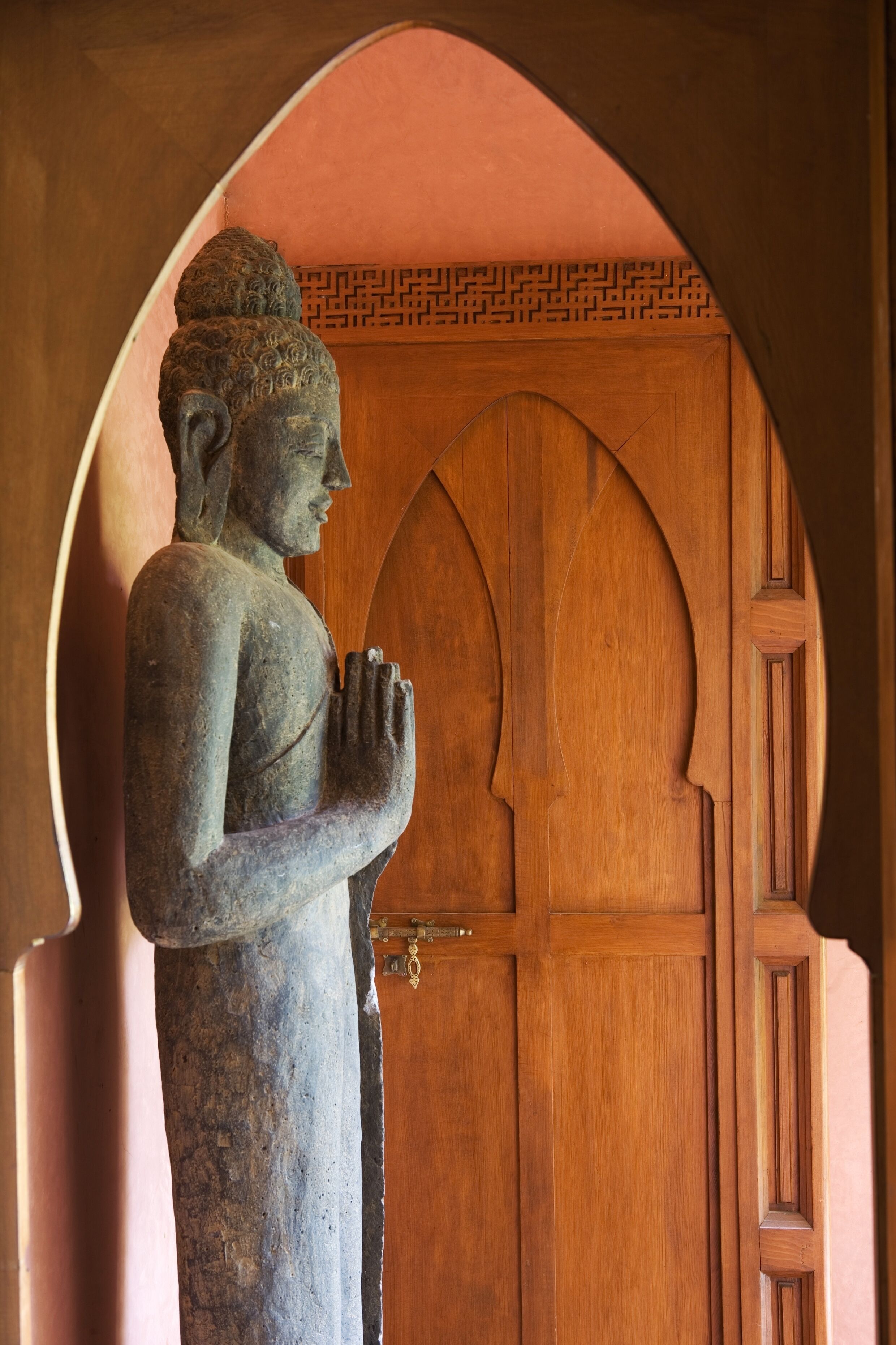 A stone statue in a doorway with a wooden door.
