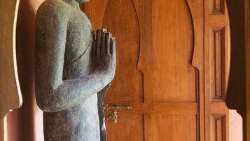 A stone statue in a doorway with a wooden door.