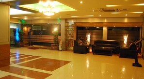 A lobby with a chandelier, a reception desk, and seating area. - Rigs Inn (Dhaka)