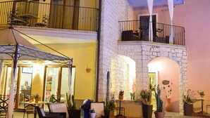 A multi-story building with outdoor seating and a swimming pool.