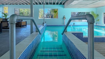 Alberca techada, alberca al aire libre y camastros