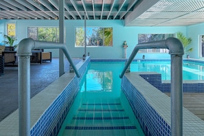 Alberca techada, alberca al aire libre y camastros