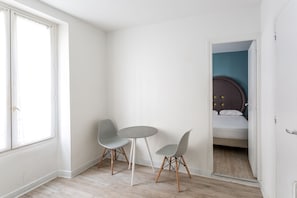 Ein kleiner, heller Raum mit einem Bett, zwei Stühlen und einem Tisch.