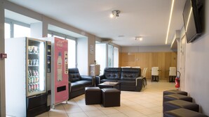 A modern lobby with a seating area, a vending machine, and a fire extinguisher. - Hotel Eiffel XV (Paris)