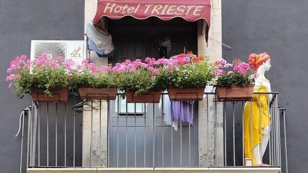 A hotel entrance with a sign for "Hotel Trieste Catania," a parking sign, and a no parking sign. - Hotel Trieste Catania (Catania)