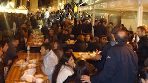 A crowded outdoor dining area with tables set for multiple people, surrounded by buildings with classical architecture. - Hotel Trieste Catania (Catania)