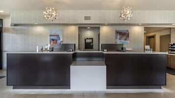 A reception area with a modern design, featuring a central counter, two side counters, and a seating area.