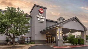 A Best Western Plus hotel with a modern design, a covered entrance, and a landscaped area with trees. - Best Western Plus Castlerock Inn & Suites (Bentonville)