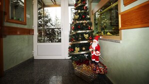 A hallway with a Christmas tree decorated with ornaments and a Santa Claus figure. - Hotel Pansion Stari Grad - Sarajevo (Sarajevo)