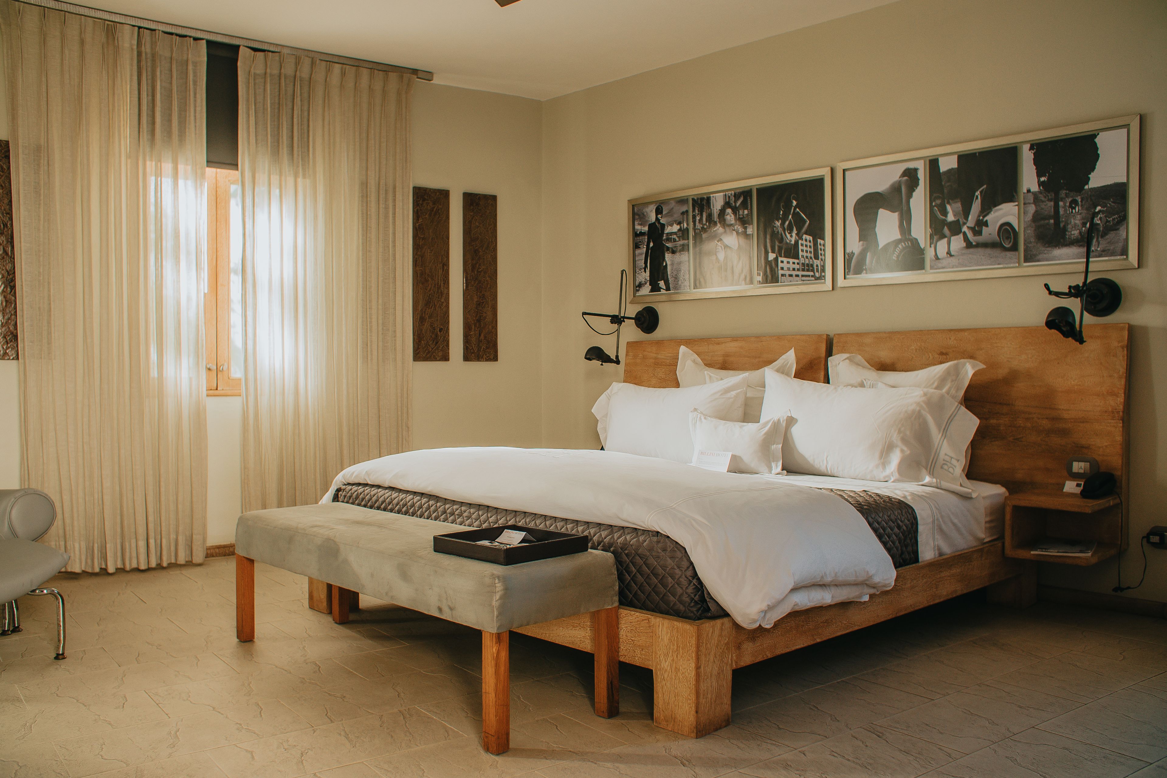 A neatly arranged bedroom with a large bed, a bedside table, a bench, and a chair.