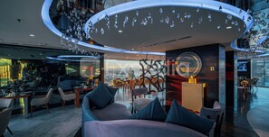 A modern interior with a circular ceiling design, seating area, and a view through a large window. - HS HOTSSON Hotel Querétaro (Querétaro)
