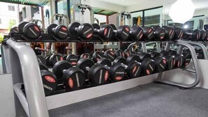 Ein Fitnessraum mit mehreren Reihen von Kurzhanteln auf Ständern.