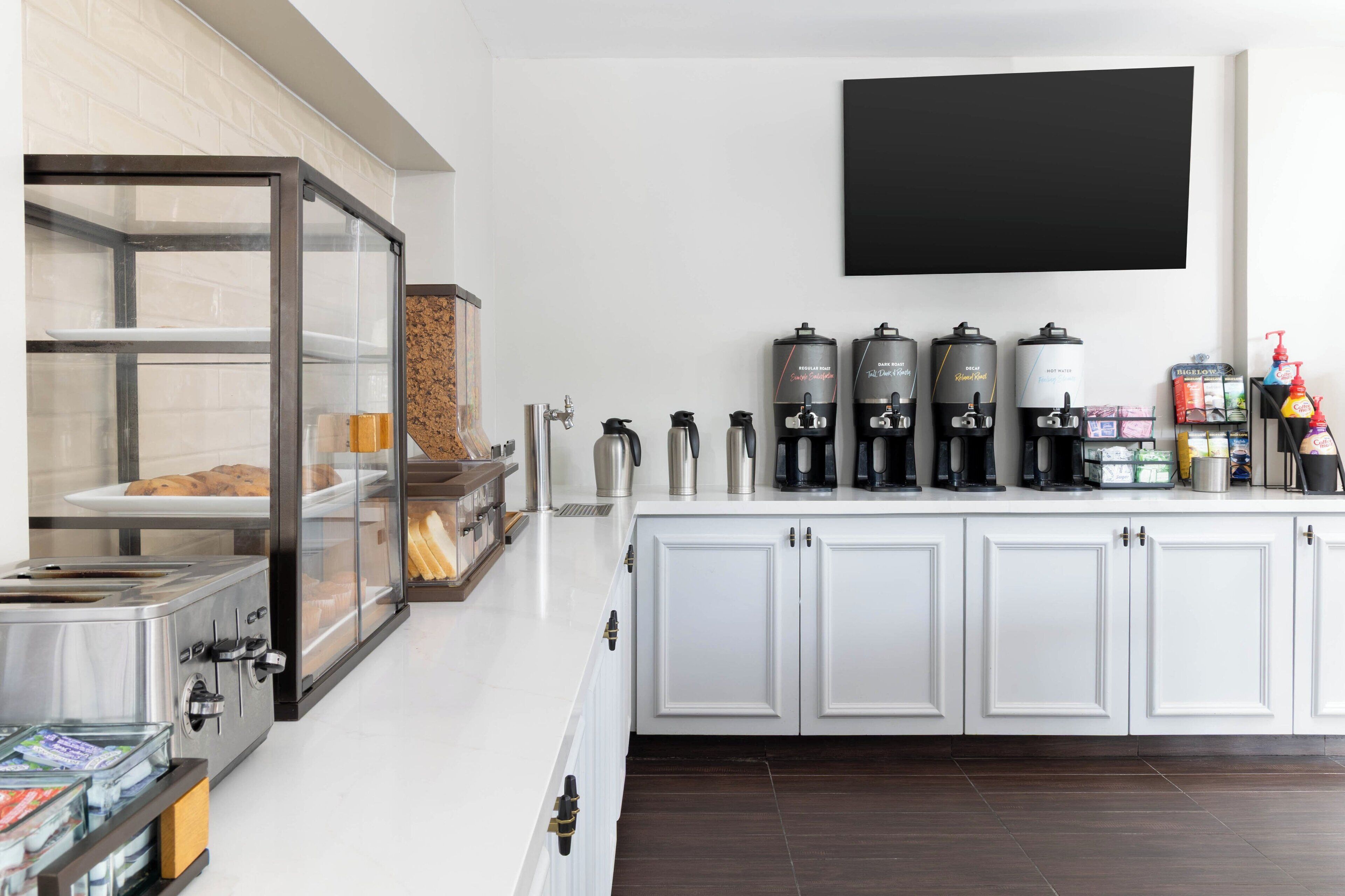 A kitchen area with a coffee station, a bread display, and a coffee machine.