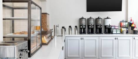 A kitchen area with a coffee station, a bread display, and a coffee machine.