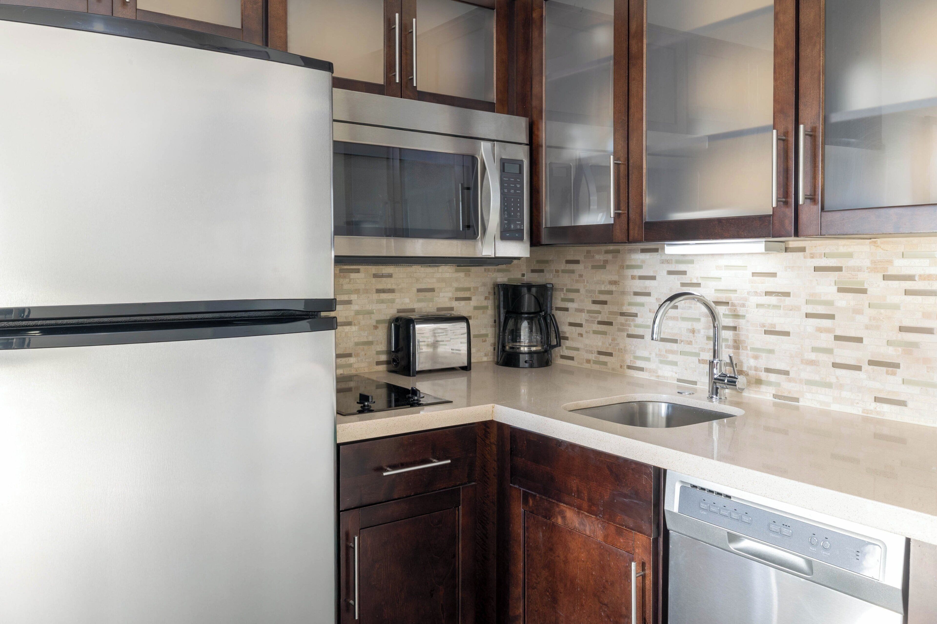 A kitchen with stainless steel appliances, a coffee maker, and a dishwasher.