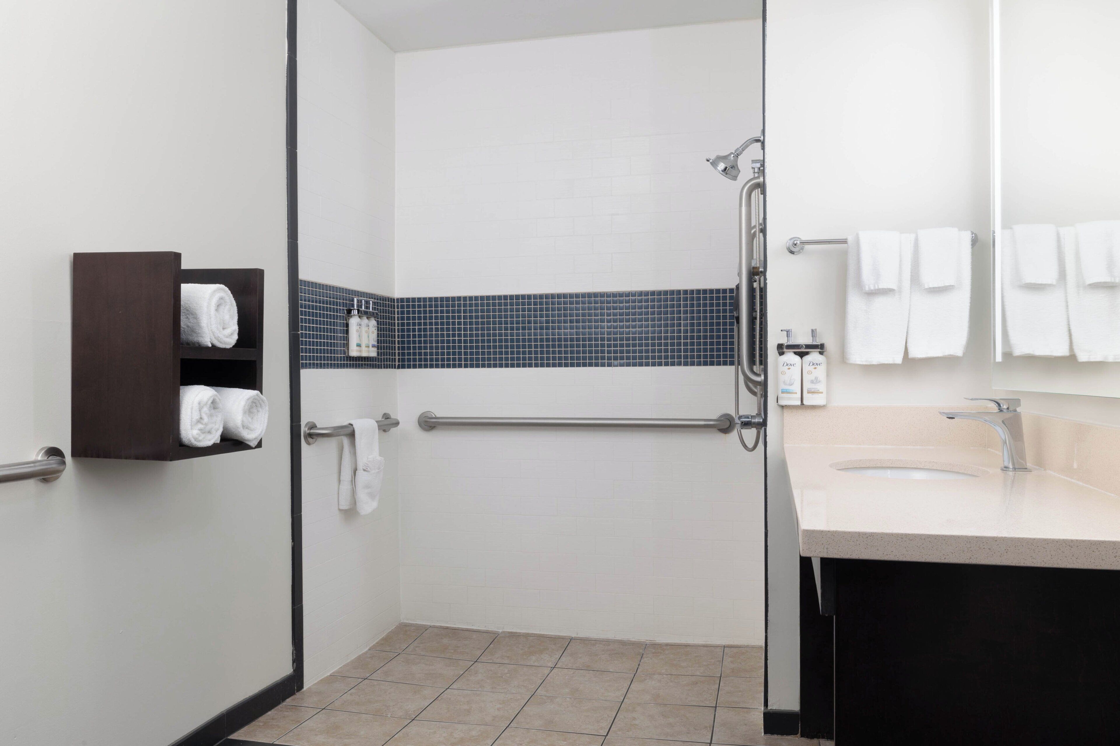 Ein modernes Badezimmer mit Dusche, Waschbecken und Handtuchhalter.