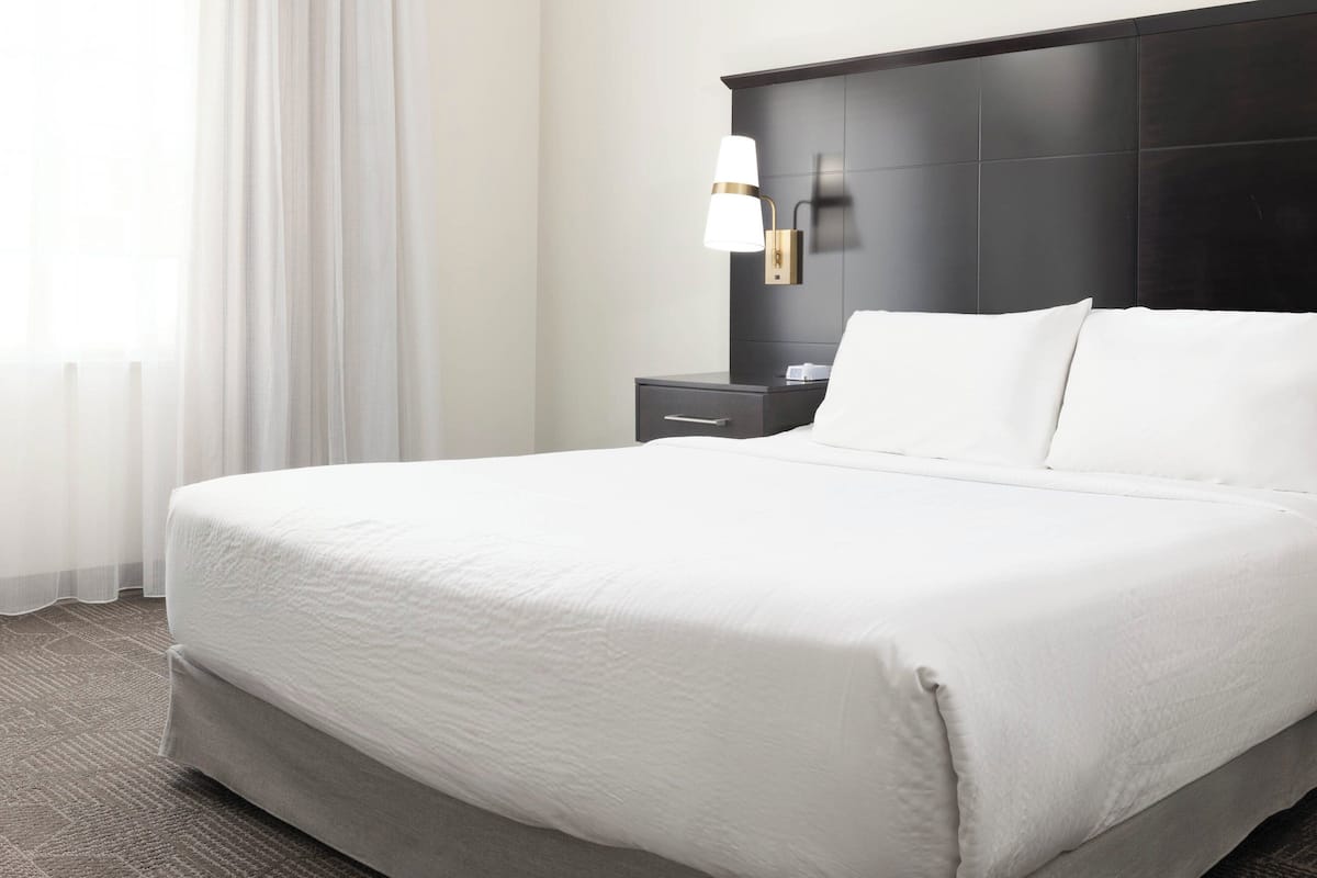 1 dormitorio, caja fuerte, escritorio y tabla de planchar con plancha