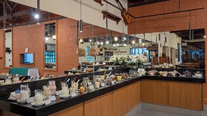 En buffet med et udvalg af mad og drikke, træskabe og hængende pendellamper.