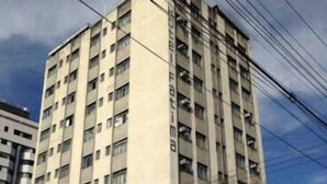 A multi-story building with numerous windows and balconies, surrounded by power lines. - Hotel Fátima (Divinopolis)