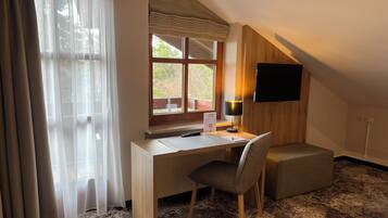 Una habitación con escritorio, silla y televisor montado en la pared.