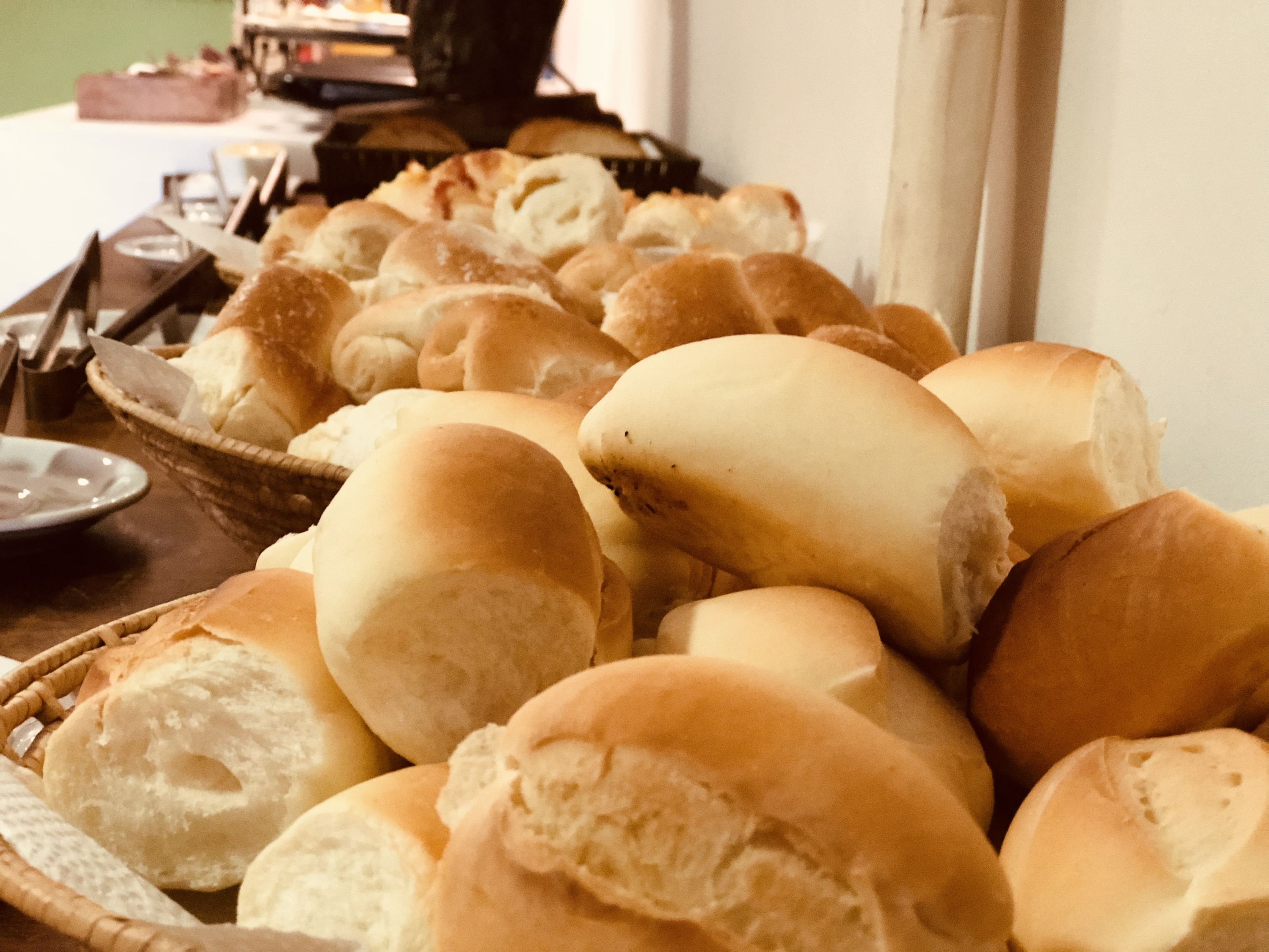 Ein Tisch mit verschiedenen Brotsorten, darunter Baguettes und Brötchen, ansprechend in Körben angeordnet.