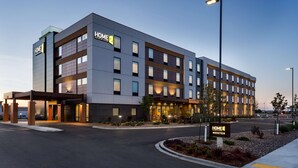 A modern hotel with a "HOME 2" sign, multiple floors, and a well-lit entrance. - Home2 Suites by Hilton Fargo, ND (Fargo)