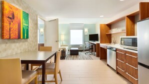 A modern kitchen with a dining area, a TV, and a microwave. - Home2 Suites by Hilton Fargo, ND (Fargo)