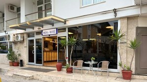 A hotel with a reception desk, outdoor seating, and potted plants. - Prima Hotel (Antalya)