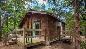 Un chalet rustique doté d’une terrasse en bois et d’un porche abrité.