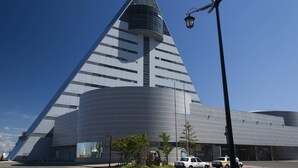 Een modern gebouw met een driehoekig dak en een gebogen basis.